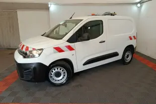 Vue 3/4 avant droite d'un Citroën Berlingo blanc 2021 avec bandes rouges réfléchissantes et toit équipé d'une rampe lumineuse.