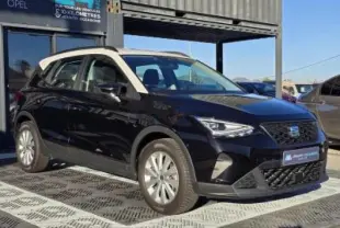 SEAT Arona 2024 noir minuit avec toit blanc, vue 3/4 avant mettant en valeur ses jantes alliage et calandre distinctive.