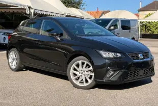 SEAT Ibiza 1.0 TSI 95 FR noire vue en 3/4 avant droit, avec jantes argentées et feux LED allumés.