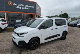 Citroën Berlingo blanc en 3/4 avant droit avec barres de toit noires et jantes alliage noires.