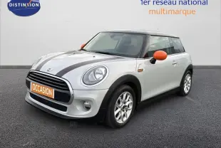 Vue 3/4 avant droite d'une MINI Hatch F56 gris clair avec rétroviseurs orange et bandes noires sur le capot.