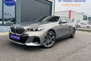 BMW Série 5 (G60) 520da gris vue 3/4 avant droit avec jantes alu et calandre imposante.