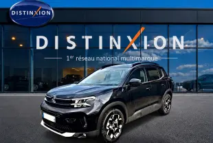 Citroën C5 Aircross noir vue 3/4 avant droit, avec jantes alu et barres de toit visibles devant showroom Distinxion.