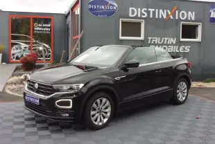 Volkswagen T-Roc Cabriolet noir en 3/4 avant droit, capote ouverte, avec signature lumineuse distinctive R-Line.