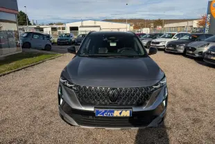 Vue avant d'un Renault Austral gris métallisé avec calandre noire et plaque Zéro KM visible.