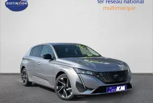 Peugeot 308 gris Artense vue 3/4 avant droit, avec calandre noire et jantes alliage distinctives.