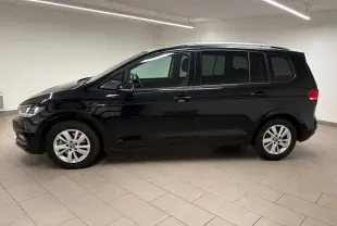 Profil côté gauche du Volkswagen Touran noir intense nacré 2024, monospace compact aux lignes épurées en intérieur neutre.