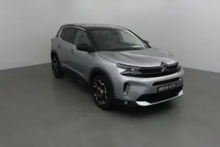 Citroën C5 Aircross 2024 gris Artense avec toit noir, vue 3/4 avant droit en intérieur neutre.