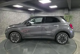Fiat 500X gris vue de profil côté gauche, avec jantes alliage 17 pouces et vitres surteintées.