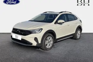 Vue 3/4 avant droite d'un Volkswagen Taigo blanc pur avec barres de toit et jantes alu sur fond neutre.