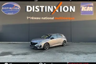 Peugeot 308 gris foncé vue 3/4 avant droit, stationnée devant un mur avec logo Distinxion en arrière-plan.