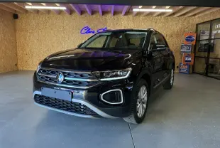 Volkswagen T-Roc noir en 3/4 avant droit, mettant en valeur sa calandre chromée et ses phares LED distinctifs.