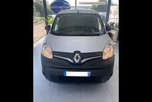 Vue avant d’un Renault Kangoo Express blanc 2022 avec pare-chocs noir et phares allumés en showroom.