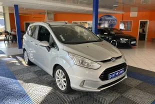 Ford B-MAX gris clair en 3/4 avant droit dans un showroom avec plaque Distinxion visible