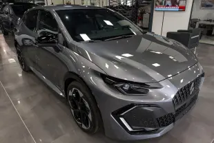 Renault Clio VI TCe 115 gris schiste vue 3/4 avant droit en intérieur, avec jantes noires et calandre distinctive.