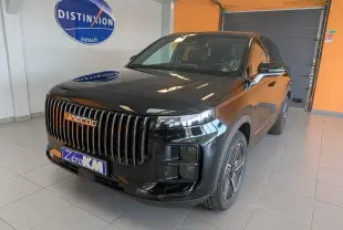 Vue 3/4 avant du SUV JAECOO J7 noir carbone métal avec calandre verticale et jantes modernes, en intérieur showroom.