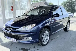 Peugeot 206 bleu en 3/4 avant droit, avec jantes alliage et phares clairs sous lumière naturelle.