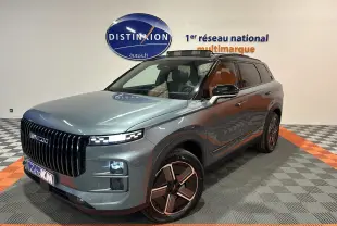 Vue 3/4 avant droit du SUV JAECOO J7 olive grey metal avec calandre verticale noire et jantes design bicolores.