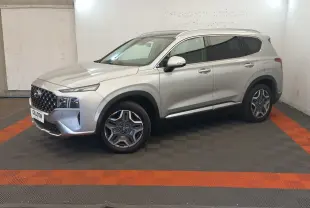 Vue 3/4 avant droite du Hyundai Santa Fe gris clair avec calandre imposante et jantes distinctives en intérieur neutre.