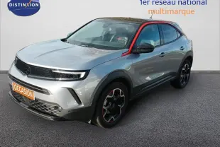 Opel Mokka GS Line gris quartz en 3/4 avant droit avec toit noir et détails rouges sur les jantes et montant de porte.