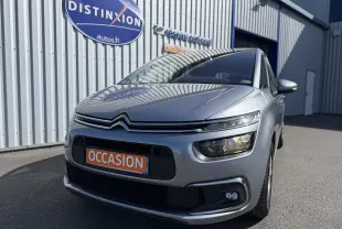 Citroën C4 Picasso gris vue 3/4 avant droit avec phares LED et plaque "OCCASION" devant un bâtiment.
