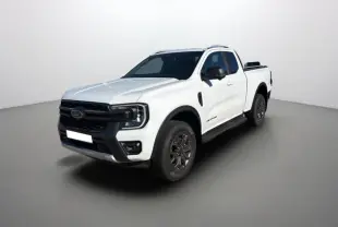 Vue 3/4 avant d’un Ford Ranger Wildtrak blanc pur avec arceau sport et barres de toit, sur fond neutre.