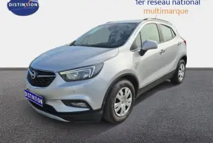 Opel Mokka X gris minéral vue 3/4 avant droit avec barres de toit et jantes acier.