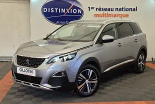 Peugeot 5008 gris clair vue 3/4 avant droit, avec jantes alliage bicolores et calandre distinctive noire.
