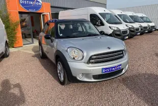 MINI Countryman gris clair vue 3/4 avant droit avec toit noir garée devant un concessionnaire Distinxion.