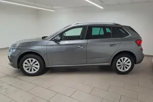 Vue de profil côté gauche d'un Skoda Kamiq gris graphite 2025 avec jantes alliage et caméra de recul intégrée.