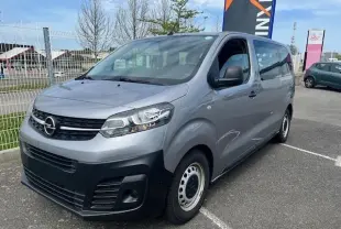 Opel Vivaro Combi gris Artense vu en 3/4 avant droit, monospace diesel 9 places avec pare-chocs noirs et jantes acier.