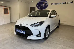 Vue 3/4 avant d'une Mazda2 blanche 2023 en hybride essence, avec calandre noire et jantes alliage en showroom.
