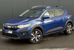 Vue 3/4 avant droite d'une Dacia Sandero Stepway 2025 Bleu Iron avec barres de toit et jantes spécifiques.