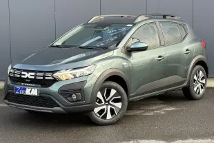 Dacia Sandero Stepway TCE 90 vert cèdre en 3/4 avant droit avec barres de toit et jantes spécifiques.