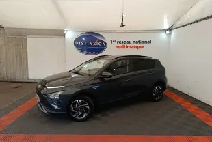 Vue de profil droit d'une Hyundai Bayon gris foncé 2023 dans un showroom avec éclairage intérieur.