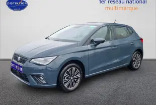 Vue 3/4 avant d'une SEAT Ibiza 1.0 TSI 95 Copa bleu gris avec jantes alliage et phares LED triangulaires.
