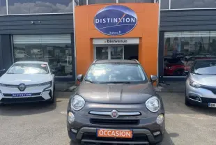 Vue avant d'une FIAT 500X bronze métallisé stationnée devant un concessionnaire avec plaque "OCCASION" visible.