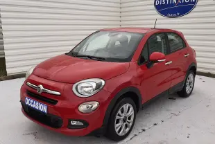 Fiat 500X rouge vue 3/4 avant droit, compacte avec jantes alliage et calandre chromée, stationnée devant un mur blanc.