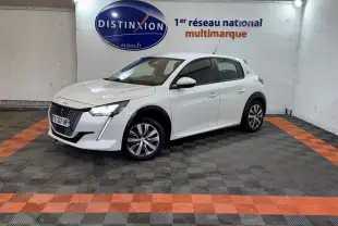 Peugeot 208 électrique blanche vue 3/4 avant droit dans un garage avec sol noir et orange.