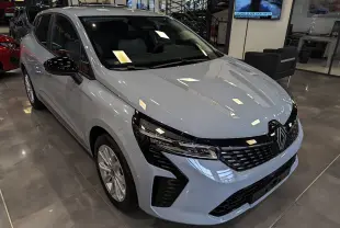 Renault Clio V Blue dCi 100 Gris Rafale vue 3/4 avant en intérieur, calandre noire et jantes alliage 16 pouces.