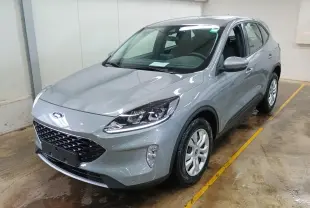 Ford Kuga gris Solar vu en 3/4 avant droit dans un garage, avec calandre noire et phares modernes.