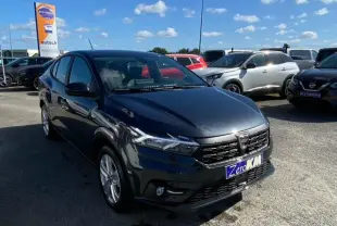Dacia Logan gris vue 3/4 avant droit, avec calandre noire et feux LED, stationnée en extérieur sous ciel bleu.