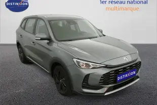 Vue 3/4 avant d’un MG ZS 1.5L hybride gris Hampstead avec calandre noire et jantes foncées.