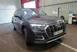 Audi Q5 gris en 3/4 avant droit, avec calandre large et jantes en alliage à 5 branches doubles.