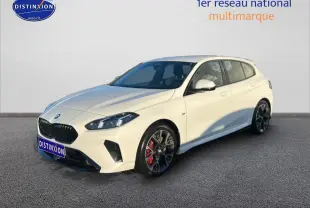 BMW Série 1 blanche alpin vue 3/4 avant droit, jantes 18 pouces bicolores et étriers de frein rouges visibles.