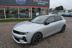 Opel Astra 2024 gris métallisé vue 3/4 avant avec toit noir et jantes alliage pentagonales diamantées.