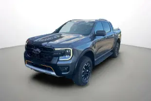 Vue 3/4 avant du Ford Ranger gris carbone 2025 avec calandre noire et détails orange sur le pare-chocs.