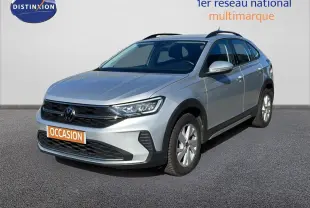 Volkswagen Taigo 1.0 TSI 110ch Life Business en reflet d'argent métal, vue 3/4 avant droit sur sol gris.