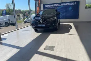 Renault Kadjar noir étoilé vu de face en showroom avec lumière naturelle et logo concession visible.
