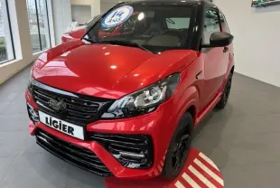 Vue 3/4 avant d'une Ligier JS50 50 Sport DCI rouge 2024 avec détails noirs brillants et jantes noires en showroom.